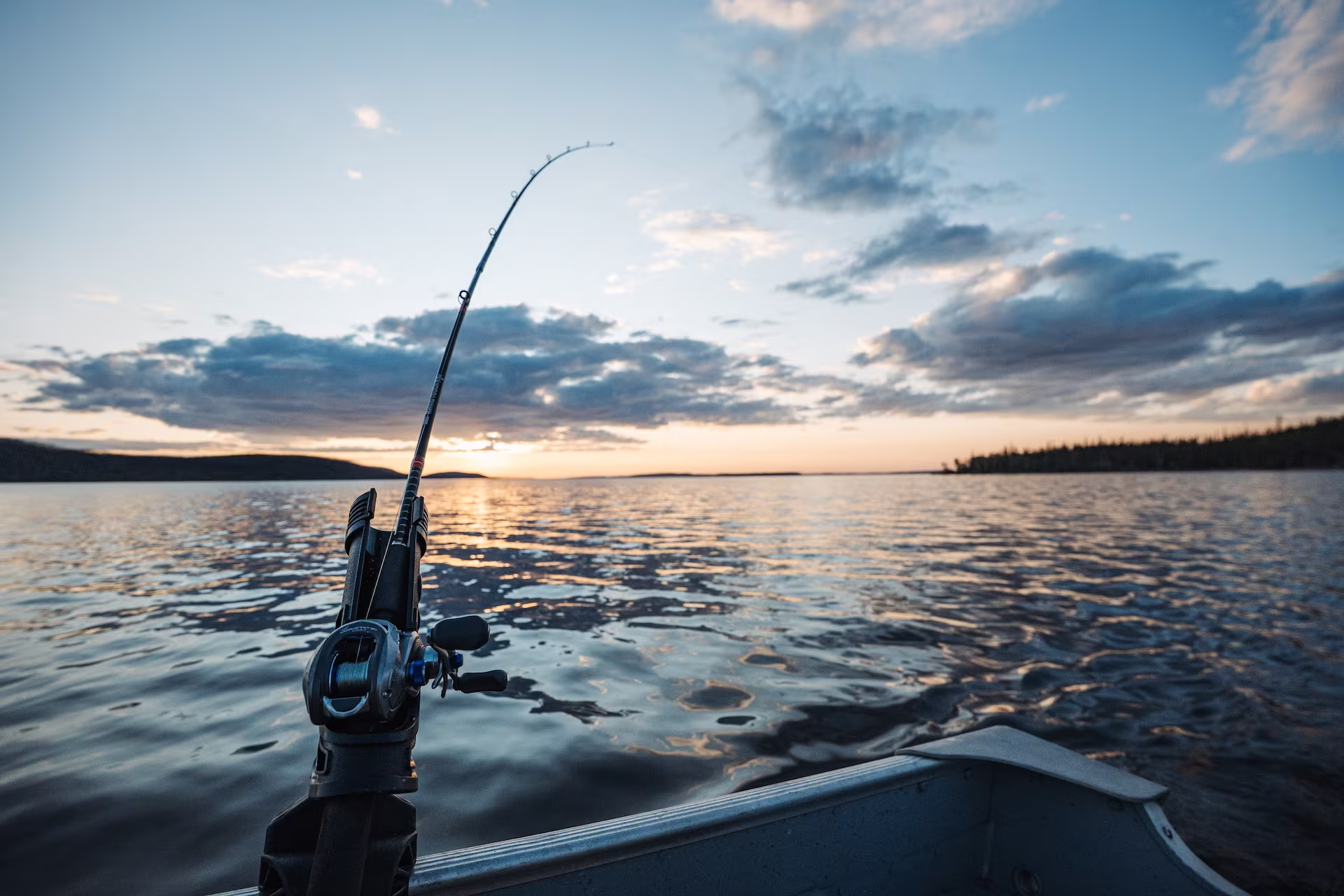A bent fishing rod in a boat on Tazin Lake.
